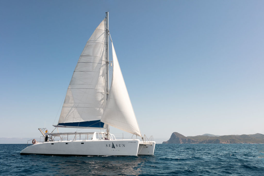 fotografia profesional publicitaria del exterior de un catamaran para pasajeros navegando en las aguas de ibiza. Fotografía de Barcos en Ibiza