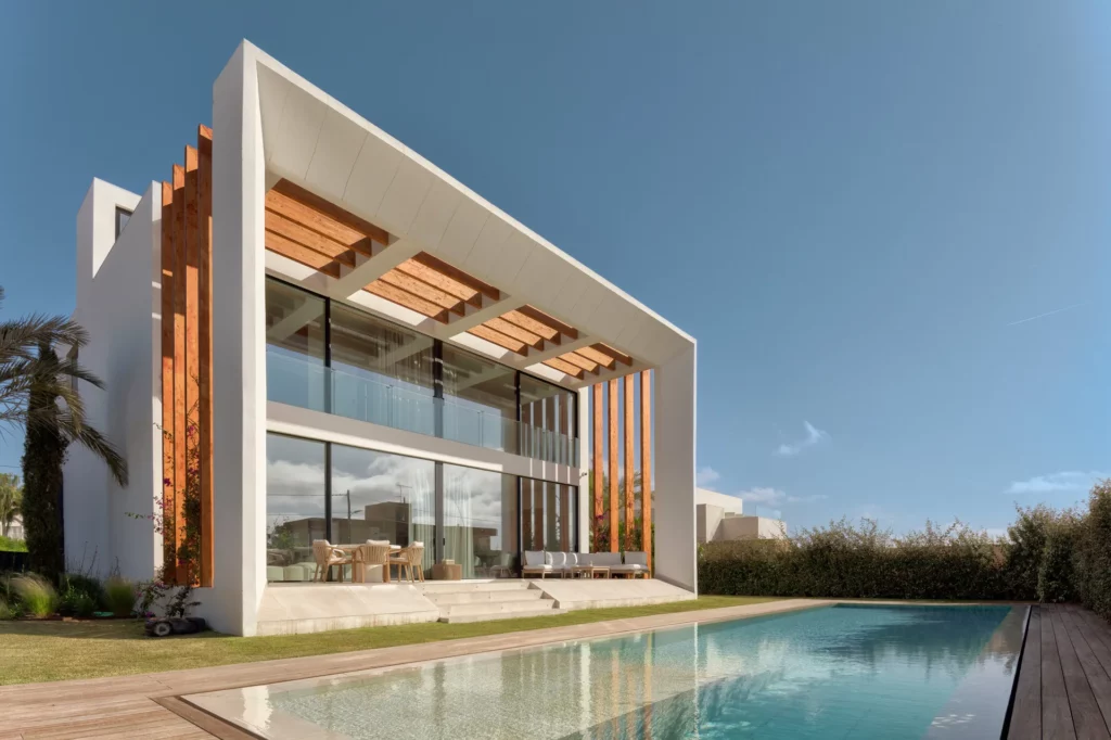 Villa contemporánea en Ibiza con fachada acristalada de doble altura y piscina exterior