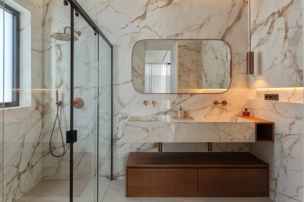 Baño de villa en Ibiza con doble lavabo veteado y ducha acristalada