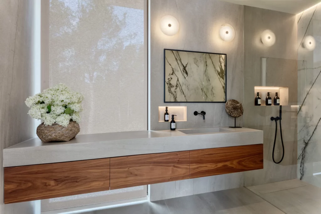 Baño de villa en Ibiza con doble lavabo suspendido de madera y ducha con mampara de cristal